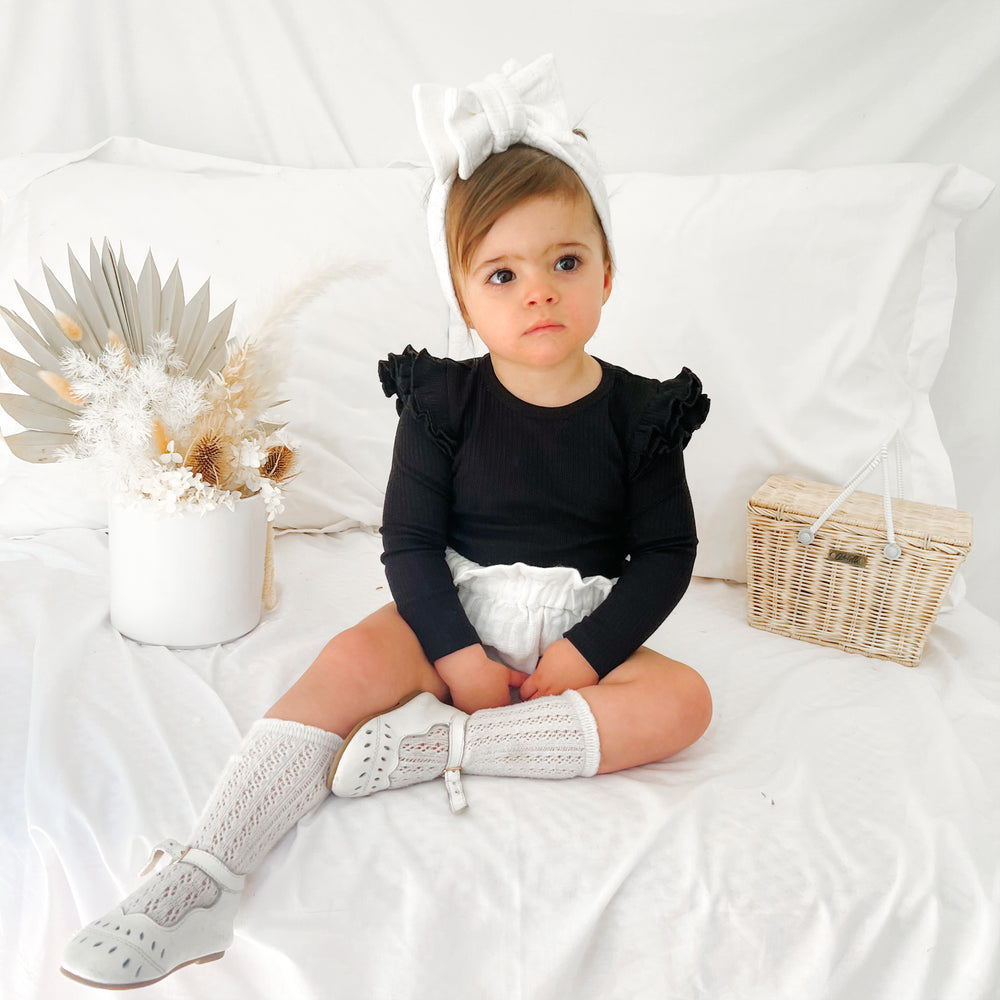 Baby girls black ribbed long sleeve bodysuit with flutter